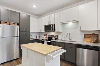 A modern kitchen with a wooden countertop and stainless steel appliances at Arcadia Cartersville Apartments, Cartersville, 30121